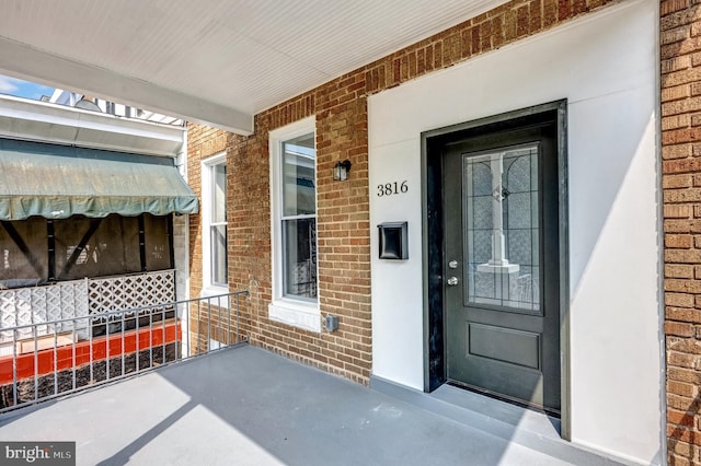 entrance to property featuring brick siding