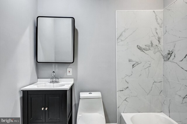 full bathroom with tiled shower / bath, vanity, and toilet