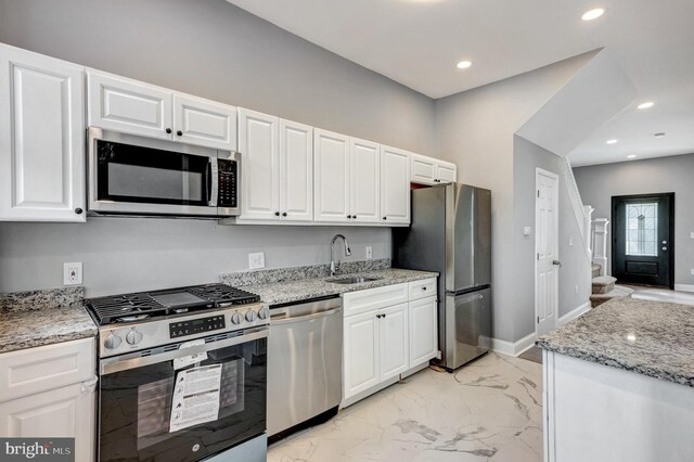 kitchen featuring light tile patterned floors, appliances with stainless steel finishes, sink, and white cabinetry