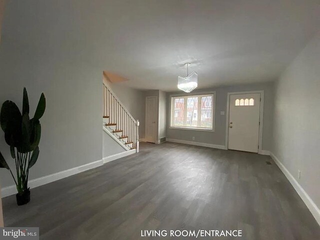 foyer with an inviting chandelier and dark hardwood / wood-style floors