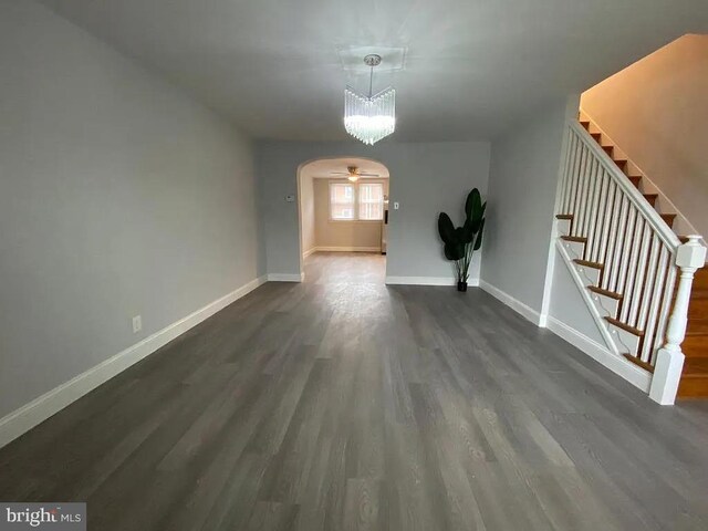 spare room with dark wood-type flooring and a notable chandelier