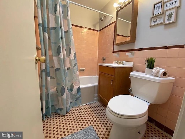 bathroom with toilet, vanity, tile walls, and shower / tub combo with curtain