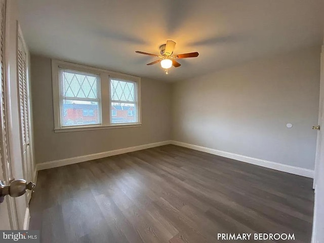 empty room with ceiling fan and dark hardwood / wood-style floors