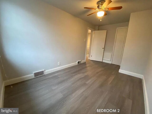 unfurnished bedroom with ceiling fan and dark hardwood / wood-style floors