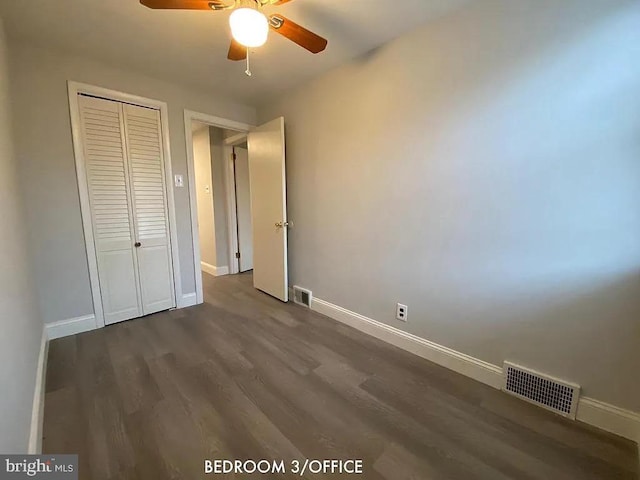 unfurnished bedroom featuring a closet, ceiling fan, and dark hardwood / wood-style floors