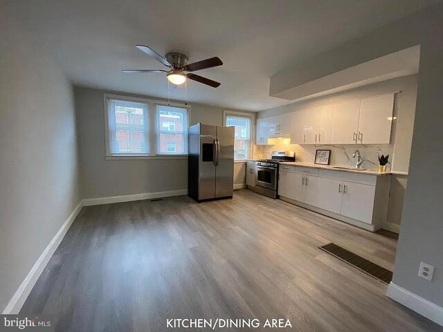 kitchen featuring stainless steel appliances, sink, ceiling fan, light wood-type flooring, and white cabinets