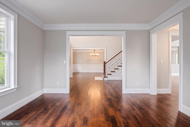 spare room with visible vents, baseboards, dark wood-style floors, an inviting chandelier, and crown molding