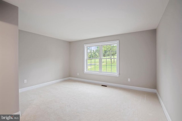 empty room with light carpet, baseboards, and visible vents