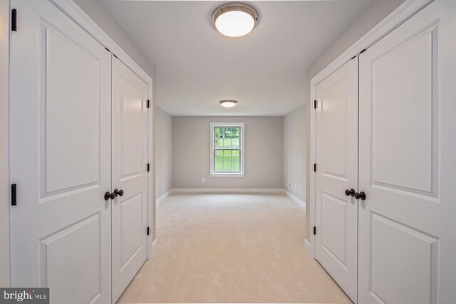 hallway with light colored carpet