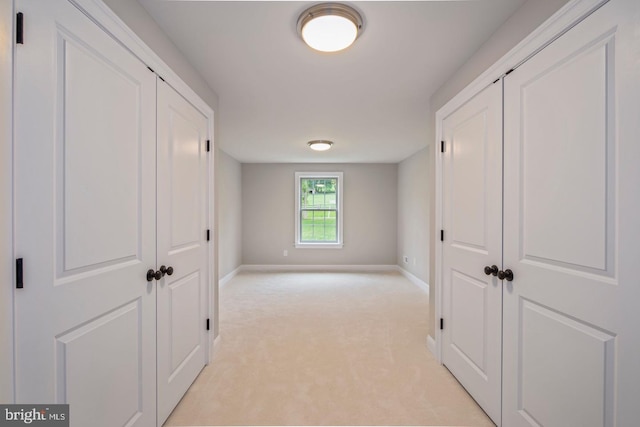 hallway with light carpet and baseboards