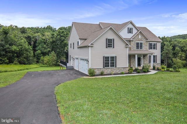 view of front facade featuring a garage, stone siding, aphalt driveway, and a front yard