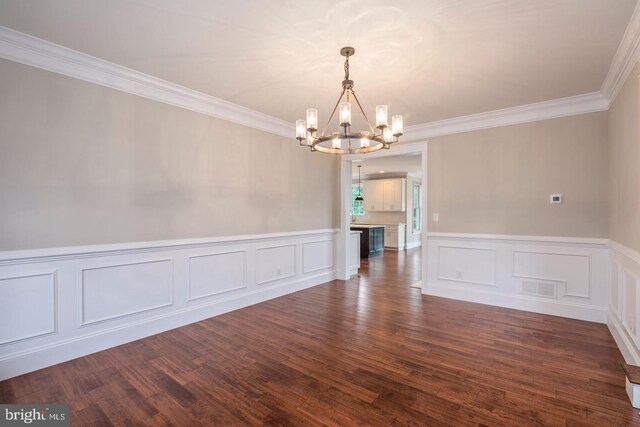 unfurnished dining area featuring crown molding, an inviting chandelier, and hardwood / wood-style flooring