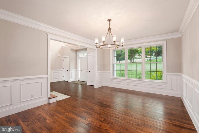 unfurnished dining area featuring ornamental molding, dark hardwood / wood-style flooring, and a chandelier