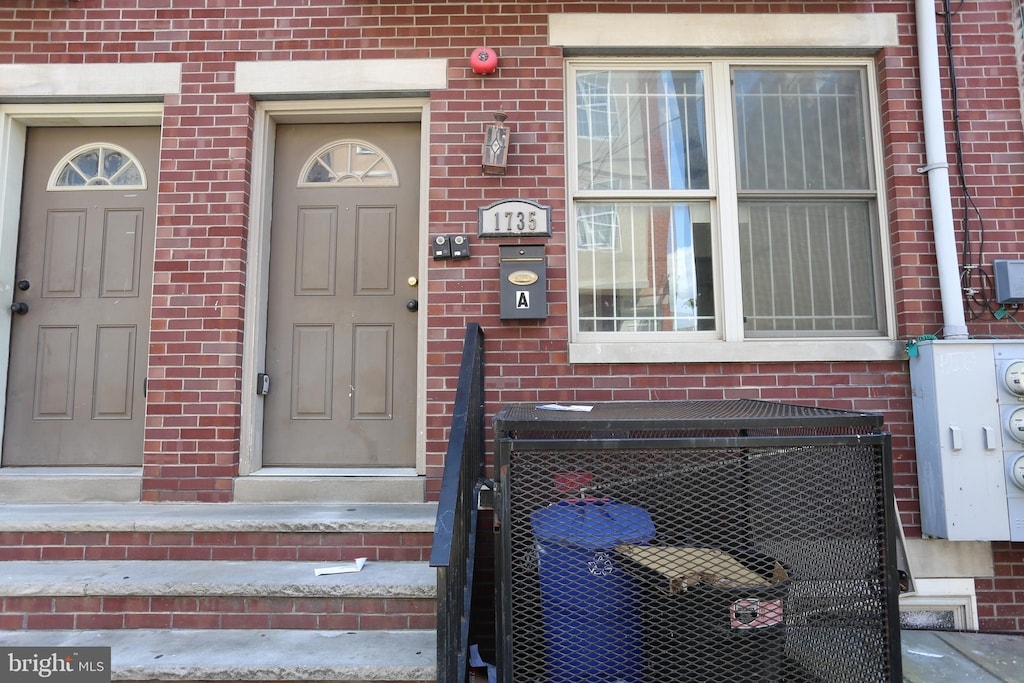 doorway to property with brick siding