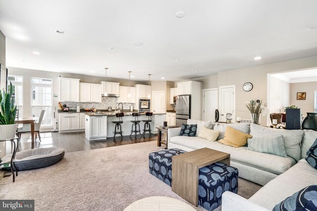 kitchen with white cabinets, a kitchen island with sink, stainless steel appliances, and plenty of natural light