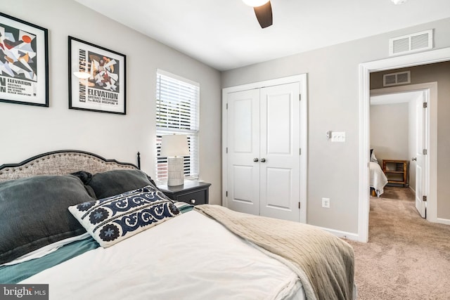 bedroom with ceiling fan, a closet, and light carpet