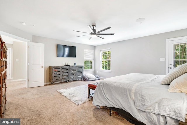 carpeted bedroom with ceiling fan, access to exterior, and multiple windows