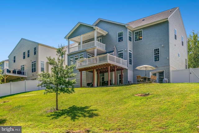 back of property with a lawn and a wooden deck