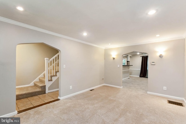 empty room with ornamental molding and light colored carpet