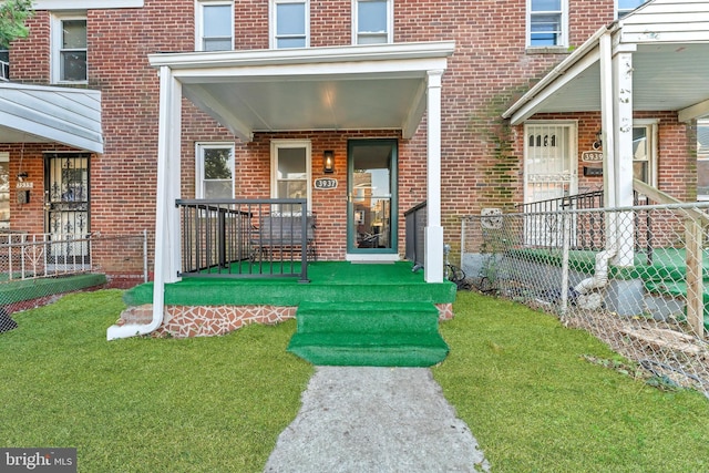 view of exterior entry featuring covered porch and brick siding