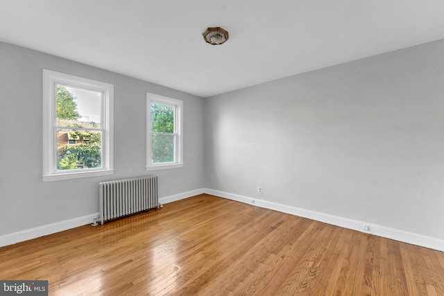 empty room with radiator and light hardwood / wood-style flooring