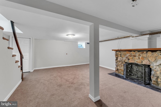 basement with a fireplace and carpet flooring