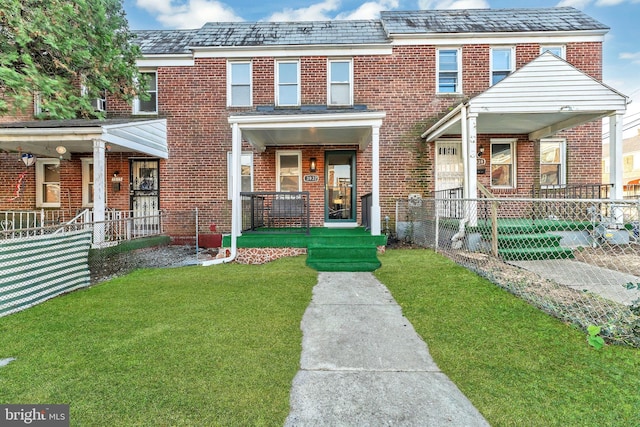 view of property featuring a fenced front yard, a high end roof, a porch, and brick siding