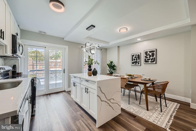 kitchen featuring decorative light fixtures, white cabinets, and a kitchen island