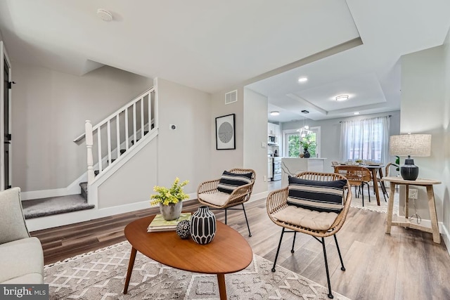 living room featuring hardwood / wood-style floors and a raised ceiling