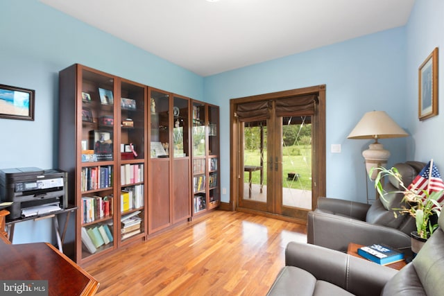 living area featuring light wood-style flooring and french doors