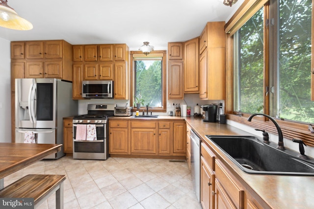 kitchen with a sink, light countertops, and stainless steel appliances