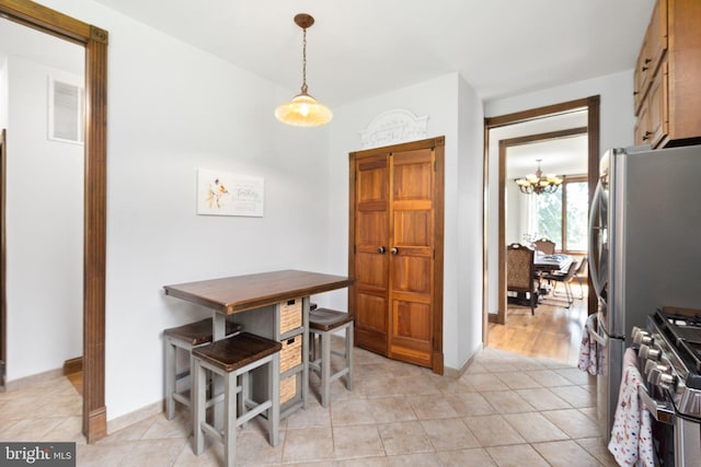 dining space featuring light tile patterned floors, baseboards, and a chandelier