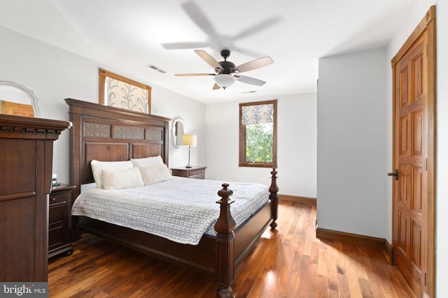 bedroom featuring ceiling fan, visible vents, baseboards, and wood finished floors