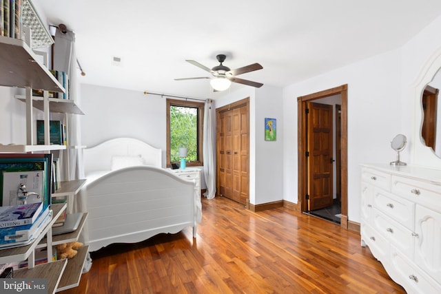 bedroom with baseboards, light wood-type flooring, a closet, and ceiling fan