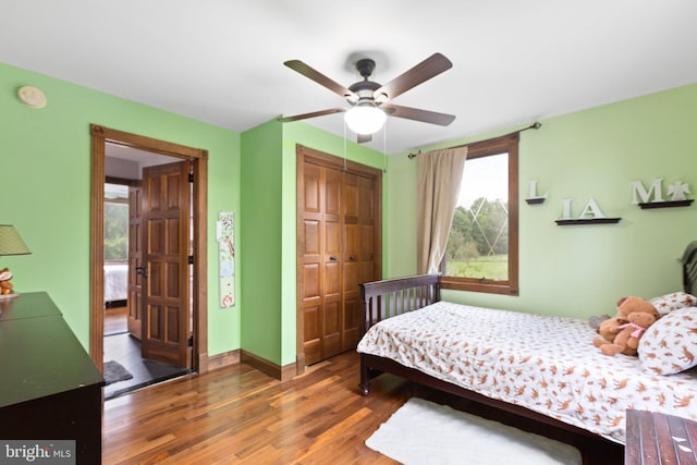 bedroom featuring a closet, ceiling fan, baseboards, and wood finished floors