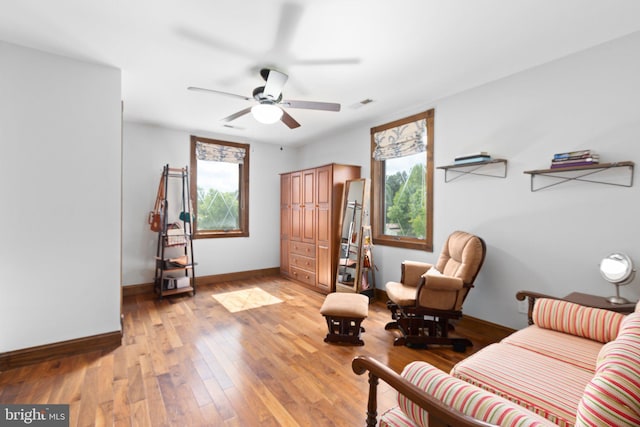 sitting room with visible vents, baseboards, ceiling fan, and light wood finished floors