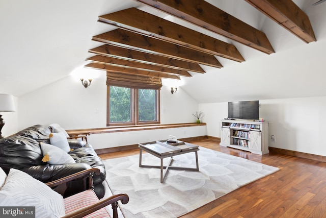 living area featuring lofted ceiling with beams, wood finished floors, and baseboards