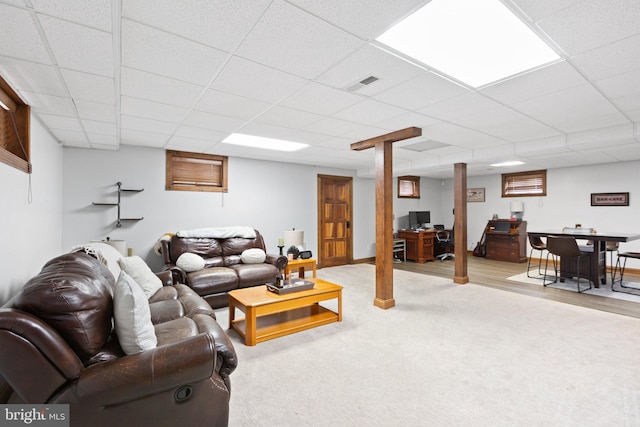 carpeted living area with a paneled ceiling and visible vents