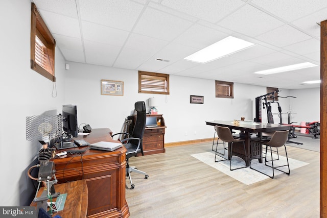 home office with a paneled ceiling, baseboards, light wood-style floors, and visible vents