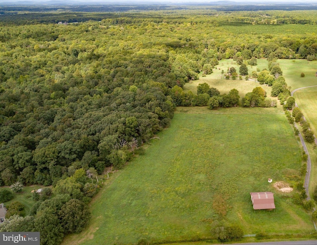 drone / aerial view featuring a wooded view