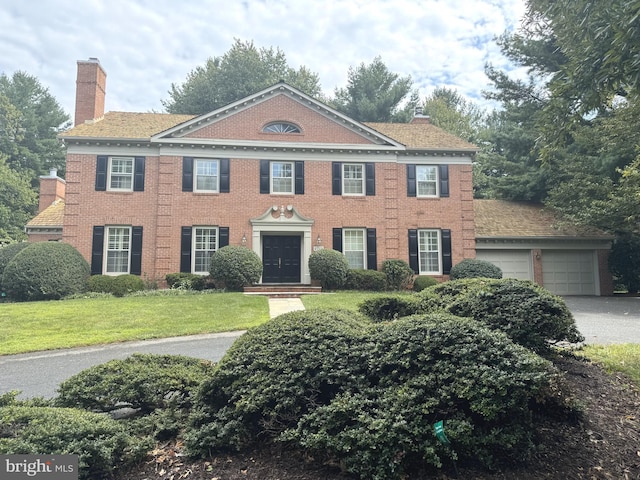 colonial-style house featuring a front yard