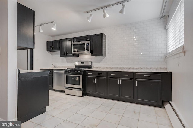 kitchen featuring appliances with stainless steel finishes, decorative backsplash, sink, light tile patterned floors, and track lighting