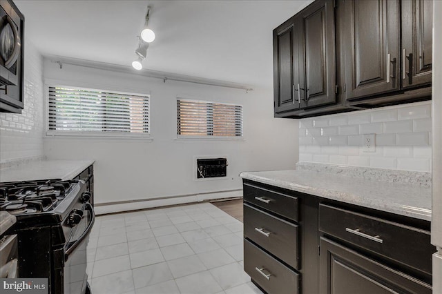 kitchen featuring decorative backsplash, rail lighting, dark brown cabinetry, stainless steel microwave, and light tile patterned floors