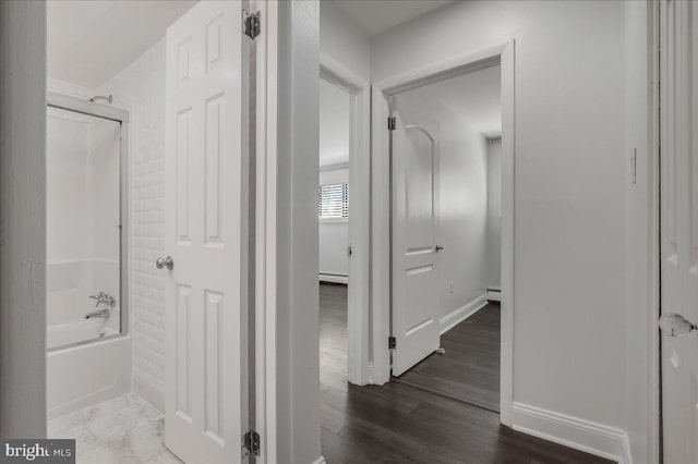 full bath featuring a baseboard heating unit, wood finished floors, bathtub / shower combination, and baseboards