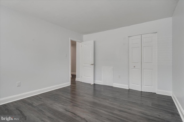 unfurnished bedroom featuring a closet and dark hardwood / wood-style flooring