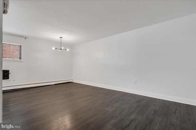 spare room featuring a notable chandelier, dark wood-type flooring, and a baseboard radiator