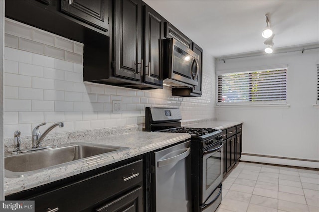 kitchen featuring backsplash, light stone counters, light tile patterned floors, sink, and stainless steel appliances