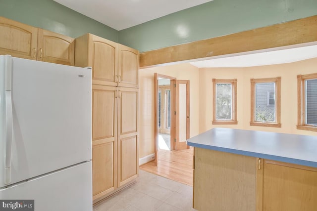 kitchen with light brown cabinetry, light wood-type flooring, and white refrigerator