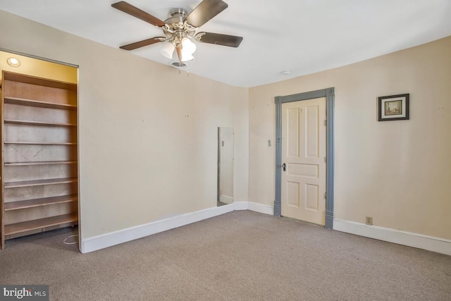 carpeted spare room with ceiling fan