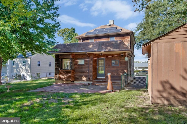 back of property with a yard and a patio